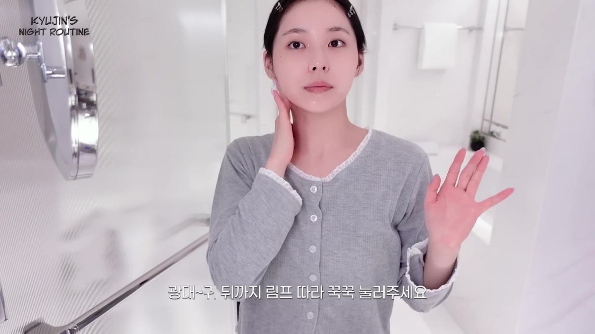 세럼을 바른 후 가볍게 손으로 림프 마사지를 하면 부기를 완화해 준다. 유튜브 <NMIXX>