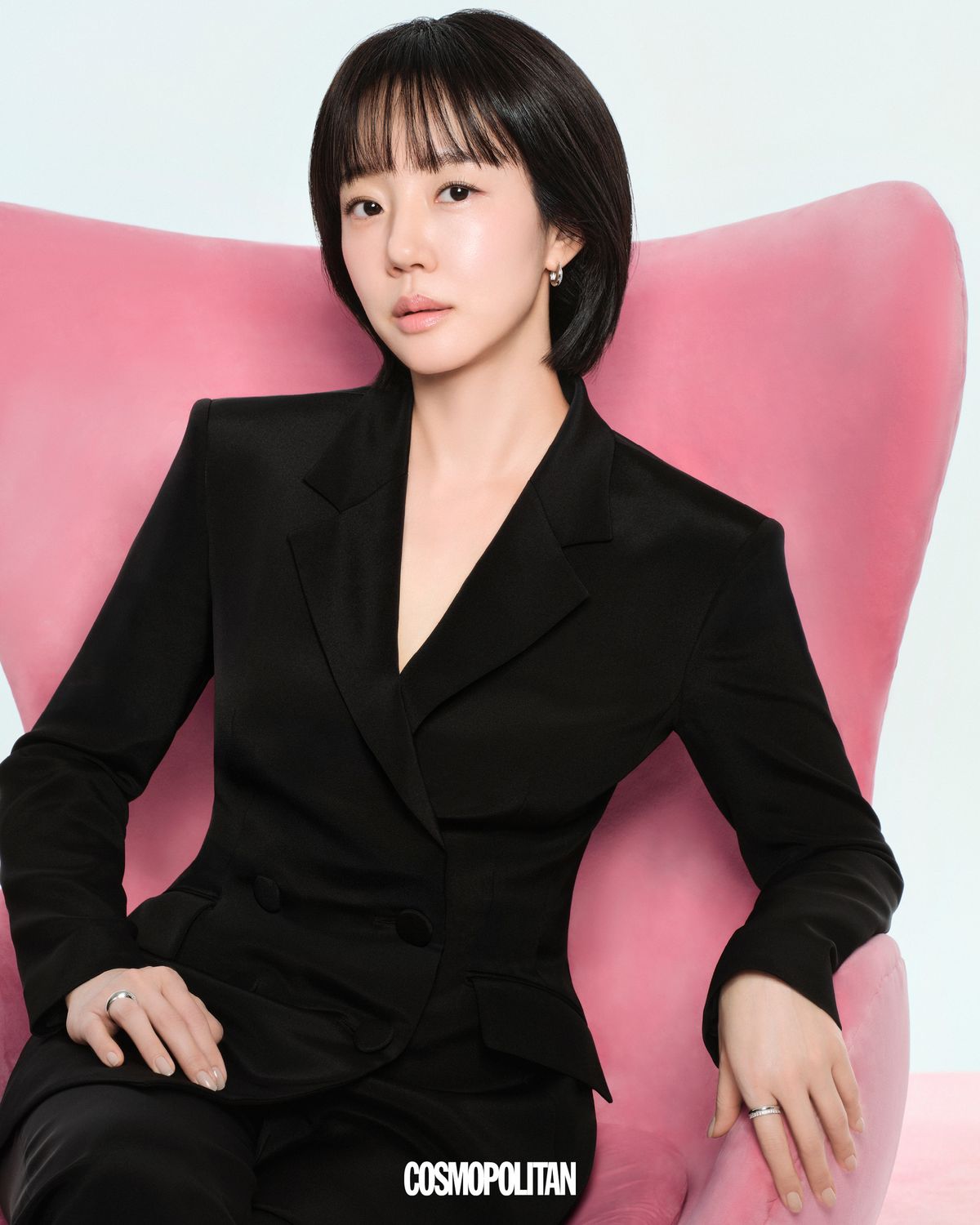 디클래시 CaHA의 브랜드 컬러인 핑크색 의자에 앉아 당당한 무드를 자아내는 그녀. 카메라를 응시하는 자연스러운 표정과 환하게 빛나는 피부가 ‘꾸밈’이 아닌 ‘본연’의 아름다움을 드러낸다. 더블 테일러드 재킷과 팬츠 모두 Avouavou. 이어링과 링 모두 Hyères Lor. 슈즈 스타일리스트 소장품.