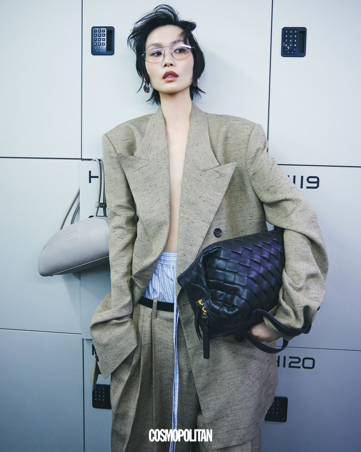 오버사이즈 재킷 5백25만원, 오버사이즈 팬츠 2백32만원, 레이어드한 트렁크 쇼츠 1백30만원, 벨트 가격미정 모두 Dolce&Gabbana. 슬림한 프레임 안경 23만2천원 Ray-Ban by EssilorLuxottica. 후프 귀고리 33만1천원 Polène. 큼직한 인트레치아토 패턴의 스쿼시 백 가격미정 Bottega Veneta. 사물함에 걸린 볼링 레더 백 4백45만원 Miu Miu.